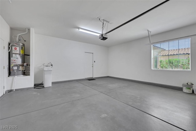 garage featuring baseboards, a garage door opener, and secured water heater