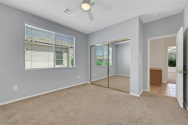 unfurnished bedroom featuring carpet flooring, a closet, ceiling fan, visible vents, and baseboards