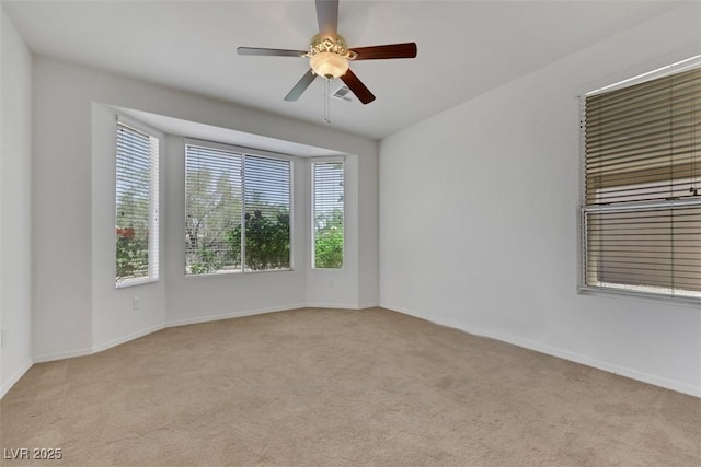 empty room featuring baseboards, visible vents, ceiling fan, and carpet flooring