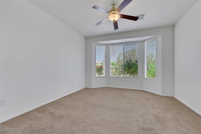 carpeted empty room featuring visible vents, ceiling fan, and baseboards