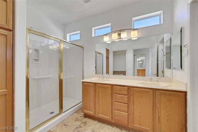 bathroom featuring a shower stall, double vanity, and a sink