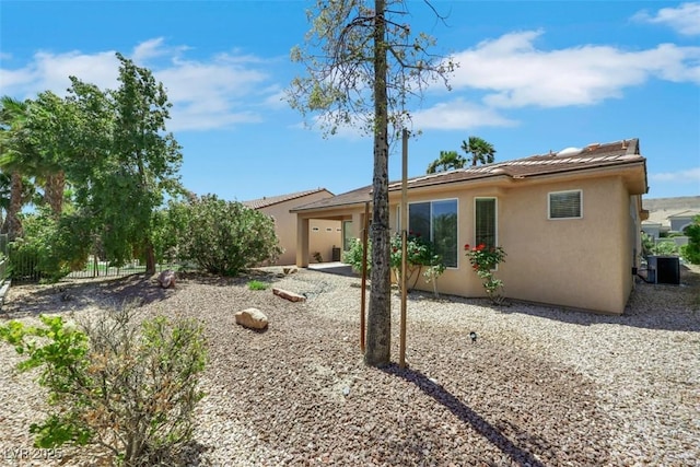 back of property featuring stucco siding, central AC, and a patio area