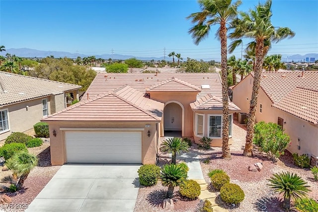 view of front of property with a garage, stucco siding, concrete driveway, and a tiled roof