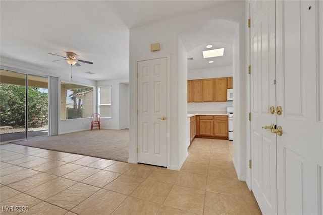 corridor with recessed lighting, light tile patterned floors, light carpet, baseboards, and a skylight