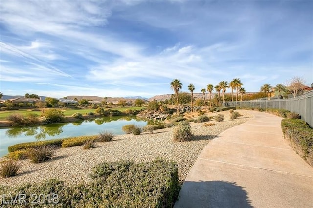 view of property's community featuring fence and a water view