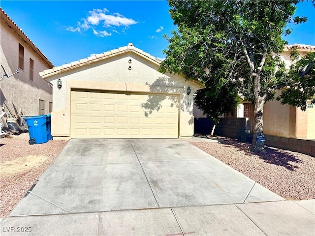 view of front of property featuring a garage, a tile roof, stucco siding, and driveway