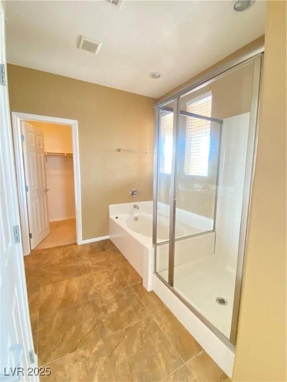 10349 Mystic Pine Rd, Las Vegas, NV 89135 - bathroom featuring a stall shower, a garden tub, a walk in closet, baseboards, and tile patterned flooring