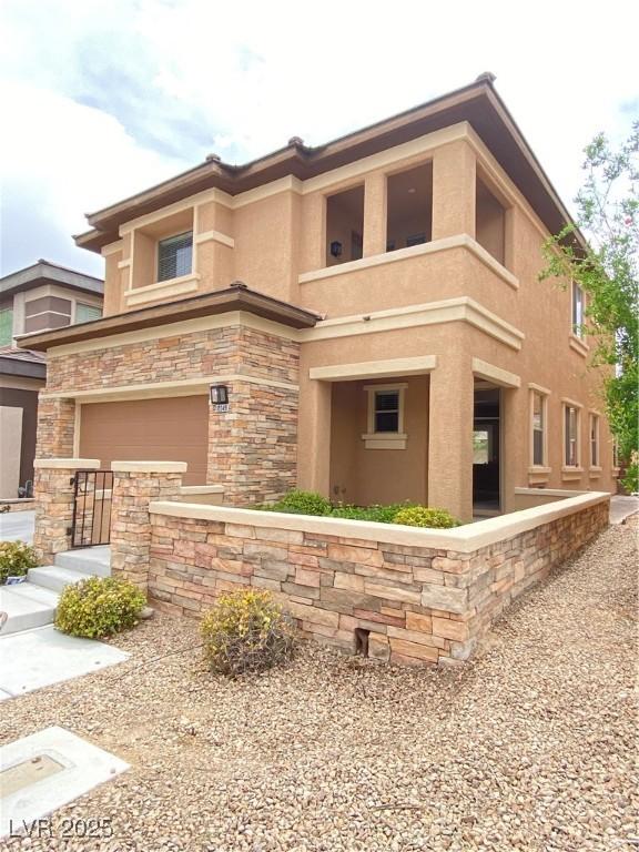 10349 Mystic Pine Rd, Las Vegas, NV 89135 - view of property exterior featuring stucco siding, a garage, and stone siding