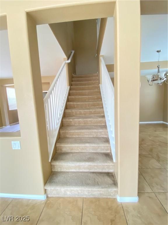 10349 Mystic Pine Rd, Las Vegas, NV 89135 - staircase featuring tile patterned flooring, a chandelier, and baseboards