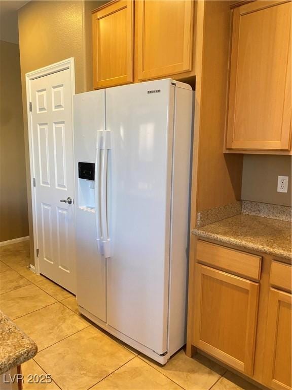 10349 Mystic Pine Rd, Las Vegas, NV 89135 - kitchen with white fridge with ice dispenser, light tile patterned floors, and light countertops