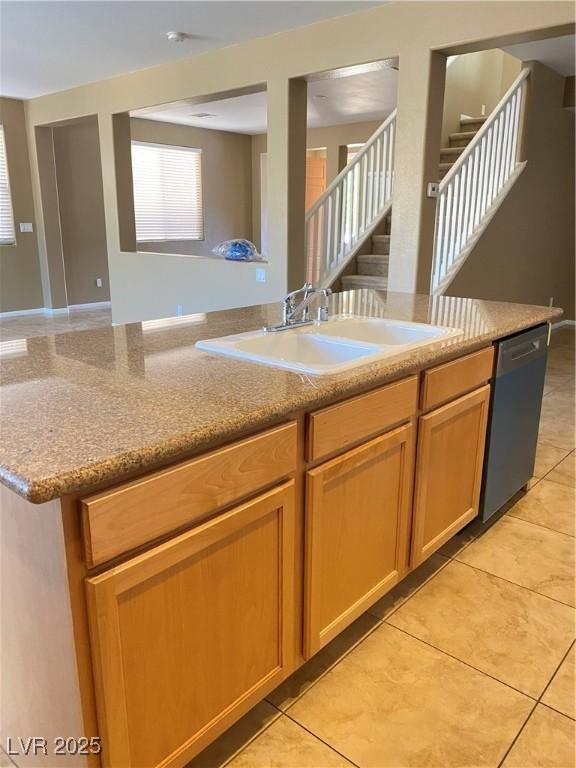 10349 Mystic Pine Rd, Las Vegas, NV 89135 - kitchen with stainless steel dishwasher, a sink, open floor plan, light tile patterned flooring, and light stone counters