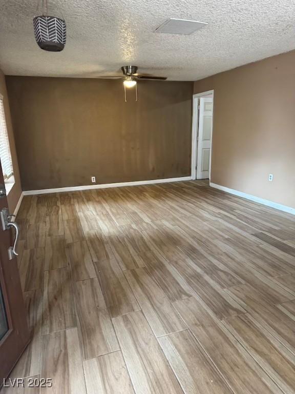 4834 E Van Buren Ave, Las Vegas, NV 89110 - empty room featuring wood finished floors, ceiling fan, baseboards, and a textured ceiling