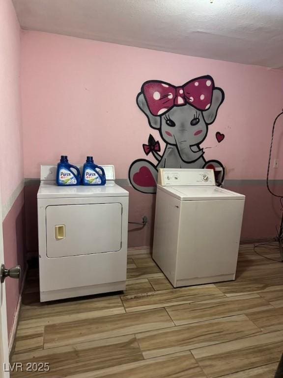 4834 E Van Buren Ave, Las Vegas, NV 89110 - laundry area featuring independent washer and dryer, light wood-type flooring, baseboards, and a textured ceiling