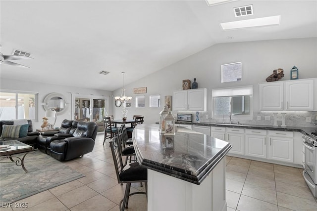 5205 Molveno Ct, Las Vegas, NV 89130 - kitchen featuring vaulted ceiling, stainless steel appliances, a chandelier, open floor plan, and a center island