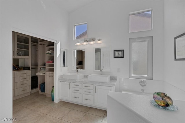 5205 Molveno Ct, Las Vegas, NV 89130 - full bath featuring a towering ceiling, double vanity, tile patterned flooring, a tub, and a walk in closet