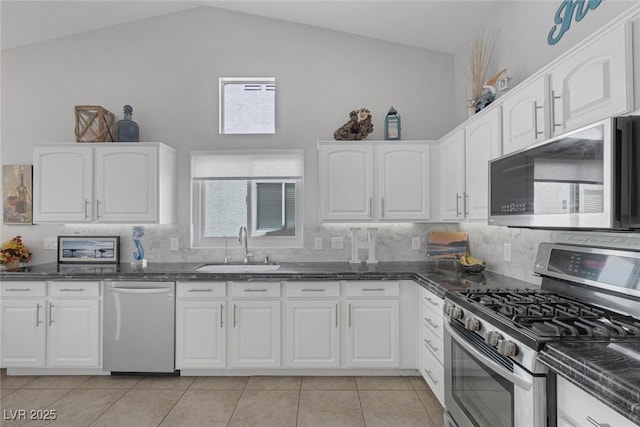 5205 Molveno Ct, Las Vegas, NV 89130 - kitchen with appliances with stainless steel finishes, light tile patterned floors, lofted ceiling, tasteful backsplash, and white cabinetry