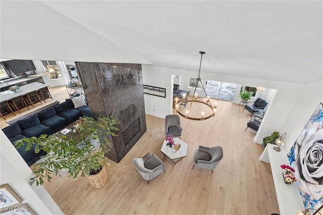 living area with an inviting chandelier, wood finished floors, and a fireplace