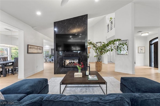 living area with a multi sided fireplace, wood finished floors, and baseboards