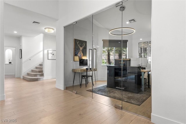 interior space featuring visible vents, hardwood / wood-style floors, baseboards, and stairs