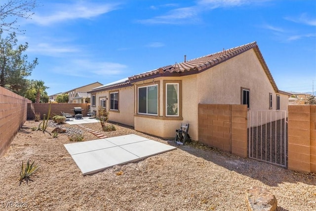 8140 Redbud Vine St, North Las Vegas, NV 89085 - rear view of property with a fenced backyard, stucco siding, a tiled roof, and a patio area