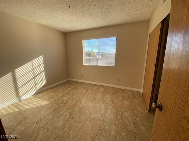 2685 Bryandouglas Dr, Las Vegas, NV 89121 - unfurnished bedroom featuring a textured ceiling, light tile patterned floors, and baseboards