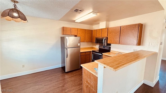 2685 Bryandouglas Dr, Las Vegas, NV 89121 - kitchen with appliances with stainless steel finishes, baseboards, dark wood-style flooring, light countertops, and a textured ceiling