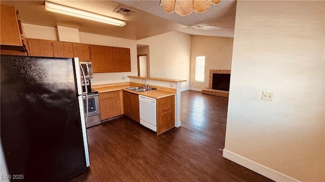 2685 Bryandouglas Dr, Las Vegas, NV 89121 - kitchen featuring stainless steel appliances, a sink, dark wood-style floors, baseboards, and a peninsula