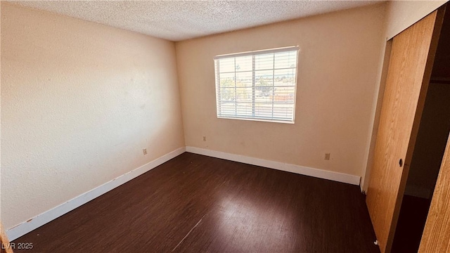 2685 Bryandouglas Dr, Las Vegas, NV 89121 - unfurnished bedroom featuring dark wood finished floors, baseboards, a textured ceiling, and a closet