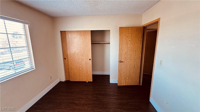 2685 Bryandouglas Dr, Las Vegas, NV 89121 - unfurnished bedroom featuring dark wood-style flooring, a closet, a textured ceiling, and baseboards