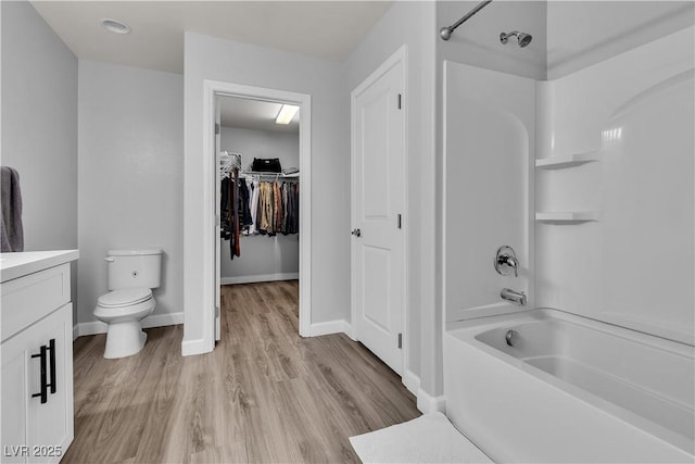 full bathroom with shower / tub combination, vanity, toilet, baseboards, and wood finished floors