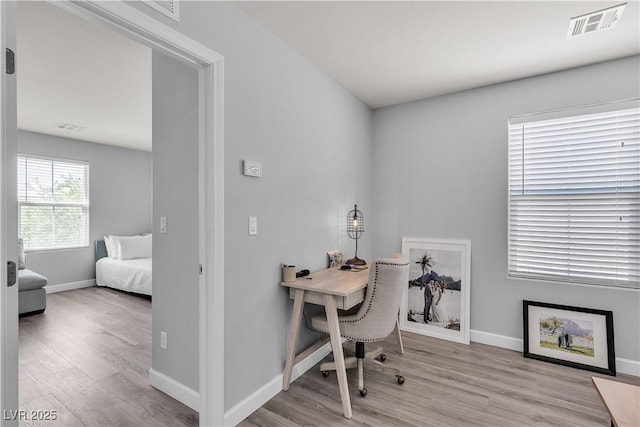 office area featuring baseboards, wood finished floors, and visible vents