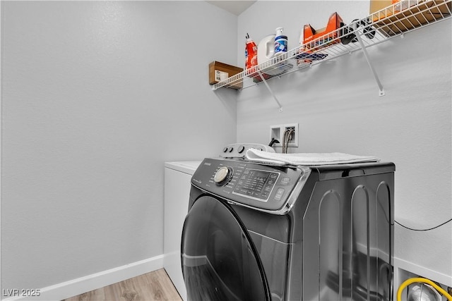 laundry room with independent washer and dryer, laundry area, baseboards, and light wood-style flooring