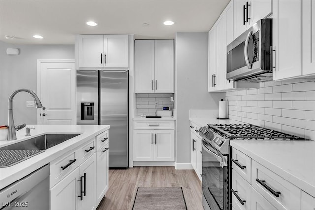 kitchen featuring a sink, white cabinets, and stainless steel appliances