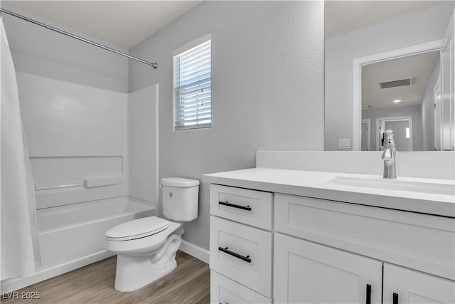 full bath featuring visible vents, wood finished floors, shower / washtub combination, vanity, and toilet