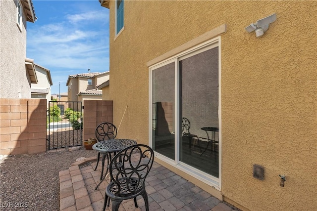 view of patio featuring fence and a gate