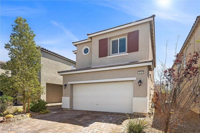 view of front of home with a garage, driveway, and stucco siding
