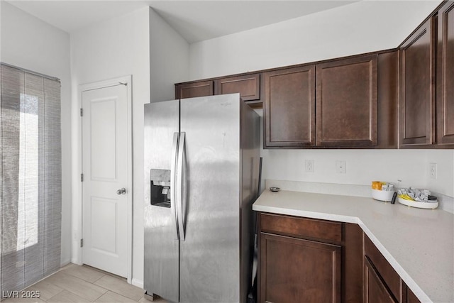 kitchen featuring light countertops, stainless steel fridge with ice dispenser, and dark brown cabinets