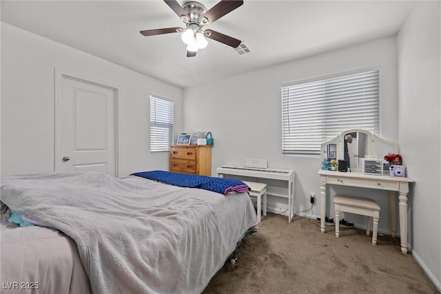 carpeted bedroom featuring baseboards, ceiling fan, and visible vents