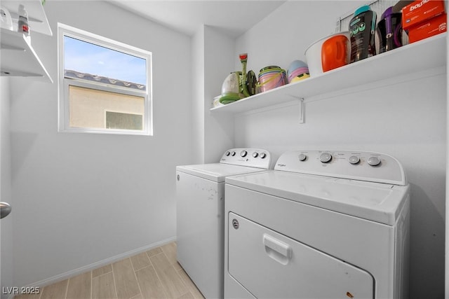 clothes washing area featuring separate washer and dryer, laundry area, baseboards, and light wood-style floors