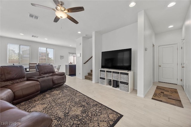living room with a ceiling fan, visible vents, stairs, recessed lighting, and light wood-style flooring