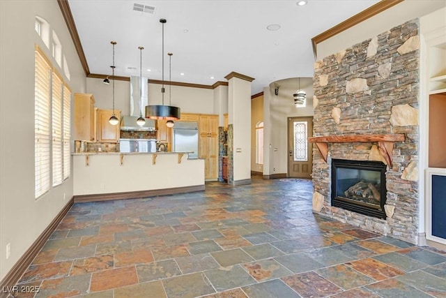interior space featuring ornamental molding, visible vents, stone tile flooring, and baseboards