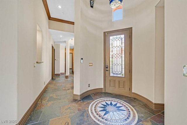 entryway featuring ornamental molding, stone tile flooring, and baseboards