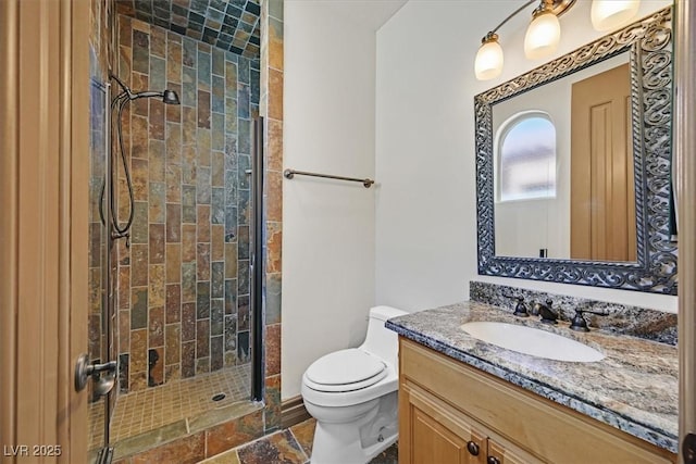 bathroom with toilet, a shower stall, and vanity