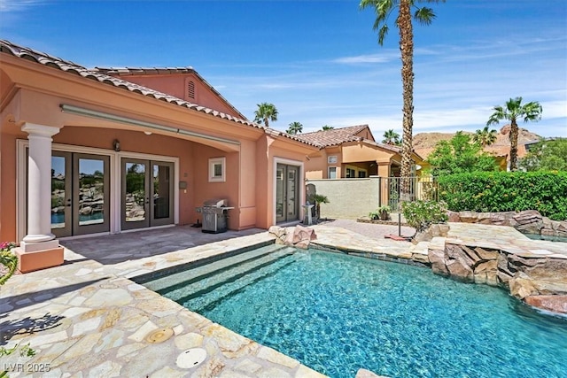 view of pool with fence, area for grilling, french doors, and a fenced in pool