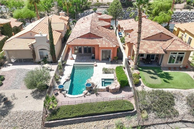 back of property featuring a tile roof, a patio, a fenced in pool, a fenced backyard, and stucco siding