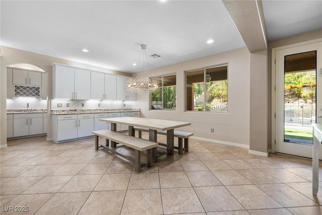 12254 Cape Cortez Ct, Las Vegas, NV 89138 - dining area featuring light tile patterned flooring, visible vents, an inviting chandelier, and plenty of natural light