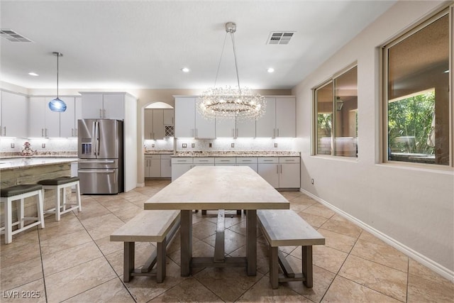 12254 Cape Cortez Ct, Las Vegas, NV 89138 - dining space with visible vents, arched walkways, an inviting chandelier, and light tile patterned floors