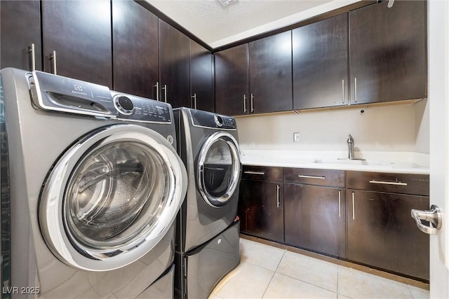 12254 Cape Cortez Ct, Las Vegas, NV 89138 - clothes washing area with light tile patterned floors, independent washer and dryer, cabinet space, and a sink