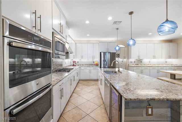 12254 Cape Cortez Ct, Las Vegas, NV 89138 - kitchen featuring tasteful backsplash, an island with sink, stainless steel appliances, a sink, and visible vents