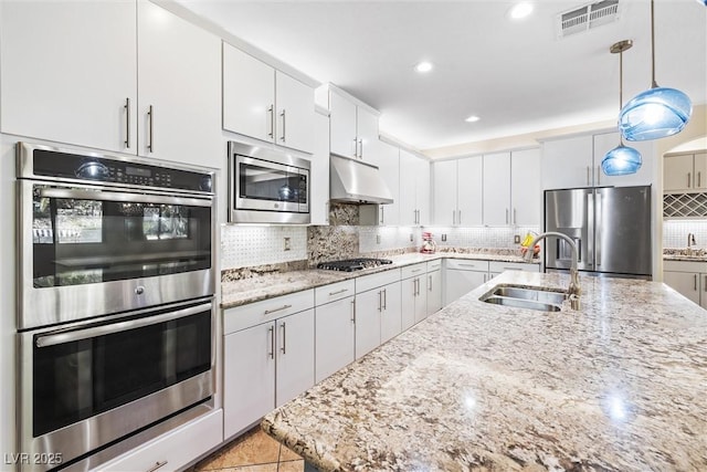 12254 Cape Cortez Ct, Las Vegas, NV 89138 - kitchen with a sink, decorative backsplash, under cabinet range hood, visible vents, and appliances with stainless steel finishes
